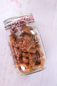 a glass jar filled with dog treats on top of a table