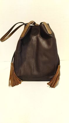 Expandable, lots of pickets, loads of room, tasselled straps to close, shoulder straps, like new-but needs a small repair at snap closure.  8"/20cmW x 12"/30cm T x 8"/20cm D Brown Fringe Shoulder Bag For Daily Use, Leather Bucket Bag With Tassels For Travel, Brown Crossbody Shoulder Bag With Tassels, Brown Tassel Crossbody Shoulder Bag, Brown Fringe Shoulder Bag For Everyday Use, Vintage Everyday Bags With Tassels, Brown Tasseled Hobo Bag, Brown Fringe Hobo Satchel Bag, Brown Tasseled Crossbody Hobo Bag