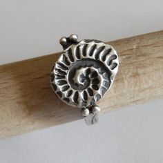 The ring is textured and oxidized, and have a modern, minimal contemporary design but a classic theme. ► MEASUREMENTS: I gave the ring a dark patina and then polished to a matte finish, except the top which is polished less to stand out. Ammonite size approx. 15 x 12 mm Ring total height: 2.4 cm The ring in the photos is ready to ship in 7.5 US size, but I can make this ring in any size you need. If the ring will be made to order, please allow 7 days after your payment. ►Please be sure of your r Antique Silver Ring With Oxidized Finish As Gift, Oxidized Sterling Silver Stackable Rings, Adjustable Stackable Rings With Oxidized Finish As Gift, Adjustable Oxidized Stackable Rings As Gift, Adjustable Stackable Rings With Oxidized Finish, Dark Silver Jewelry, Fossil Ring, Minimal Contemporary, Photo Ring