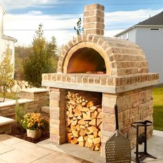 an outdoor brick oven with firewood stacked in it