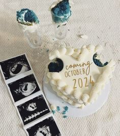 a heart shaped cake sitting on top of a table next to pictures and an album