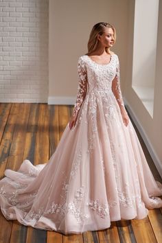 a woman in a wedding dress standing on a wooden floor