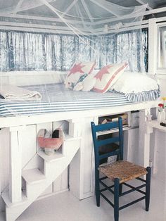 a bedroom with a bed and desk in the corner, next to a window covered by mosquito netting