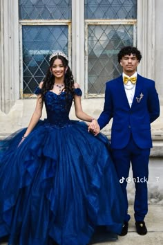 a young man and woman in formal wear holding hands