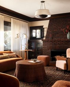 a living room filled with furniture and a fire place in front of a brick fireplace