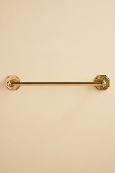 an old fashioned brass toilet paper holder with two handles and knobs on the wall