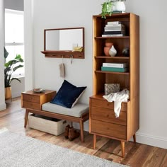 a living room with a bookcase, chair and mirror on the wall next to it