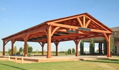 a large wooden structure sitting on top of a lush green field