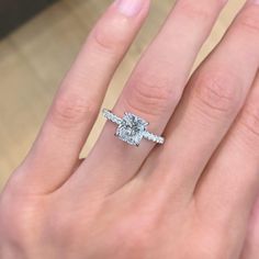 a woman's hand with a diamond ring on top of her finger and an engagement band