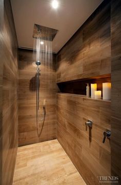 the shower head is connected to the wall in this bathroom with wood paneled walls and flooring