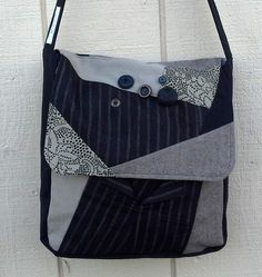 a handbag hanging on the wall with buttons in it's pocket and two pockets