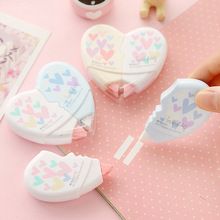 three heart shaped candy lollipops sitting on top of a pink tablecloth