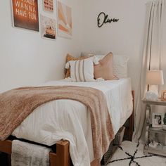 a bedroom with a bed, nightstand and pictures on the wall