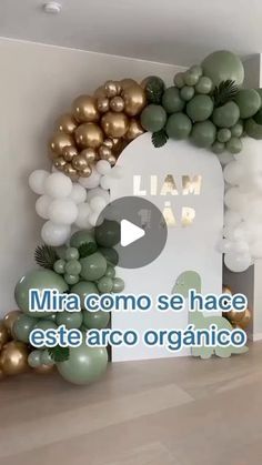 an arch made out of balloons and greenery with the words i am in spanish