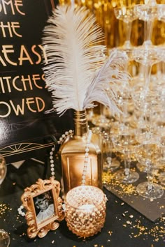 a table topped with champagne glasses and a vase filled with feathers