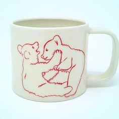 a ceramic mug with a drawing of a bear and a mouse on it's side