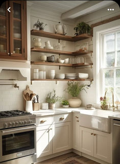 a kitchen filled with lots of white counter tops and wooden shelves next to a stove top oven