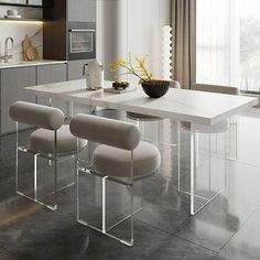 a white table with four chairs around it in the middle of a large kitchen area