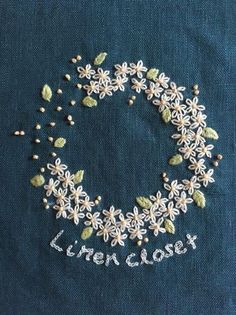 a close up of a piece of cloth with flowers and leaves in the shape of a circle