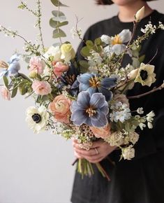 a woman holding a bouquet of flowers in her hands