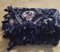 a blue bag with white and black designs on it sitting on the ground next to a tile floor