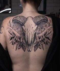 the back of a woman's shoulder with an eagle and skull tattoo on it