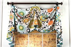 the window is decorated with colorful flowers and swirls on it's valance