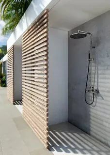 an outdoor shower with wooden slats on the wall