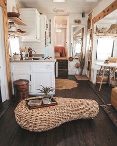 a living room filled with furniture next to a kitchen