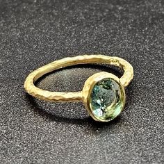 14k solid yellow gold hammered ring with 1.35 ct. 8x6 mm oval shape natural AAAA blue green aquamarine, this is truly a rear nature find, mesmerizing green & blue colors make this ring a one of a kind piece, this item can also be ordered in white or rose gold in different color gemstones such as, amethyst, pink amethyst, green amethyst, Swiss blue topaz, London blue topaz, white topaz, citrine, garnet, smoky quartz, peridot, morganite, aquamarine, pink tourmaline, green tourmaline, emerald, ruby Unique Oval Yellow Gold Topaz Ring, Handmade Oval Sapphire Ring In 14k Gold, Handmade 14k Gold Oval Emerald Ring, Handmade Oval Emerald Ring In 14k Gold, Handmade Gold Topaz Ring With Oval Shape, Handmade Gold Topaz Ring In Oval Shape, Hand Forged Oval Sapphire Ring For Anniversary, Unique Oval Aquamarine Rings, Unique Aquamarine Oval Rings