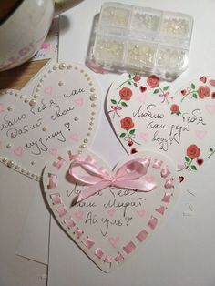 two heart shaped magnets with writing on them next to an empty pill box and spoon