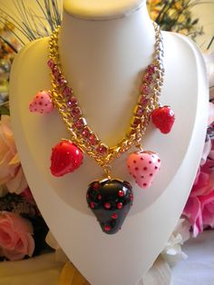 Chunky and fun strawberry charms inlay with crystals and rhinestones yellow gold plated chain statement necklace by betsey johnson.  the necklace is new.  the chain is 16 inches in length and has a 3 inch extender with a lobster claw clasp closure and signed logo charm in place.  the inner chain is inlay with pink crystals.  the center strawberry measures 2 by 1.5 inches in size.   beautiful necklace, fun to wear, makes a great gift or addition to a collection.  thank you and take care. Cute Party Jewelry With Chain Detail, Cute Party Jewelry With Chain, Dollette Core, Lesbian Earrings, Strawberry Charm, Chunky Statement Necklace, Belly Piercing, Betsey Johnson Jewelry, Love Spells