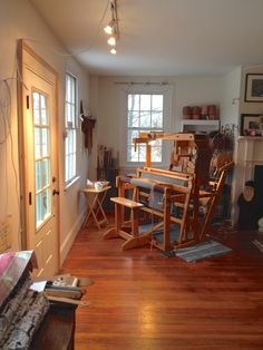 a living room filled with furniture and a fire place next to a window on top of a hard wood floor