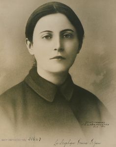 an old black and white photo of a woman with short hair wearing a collared shirt