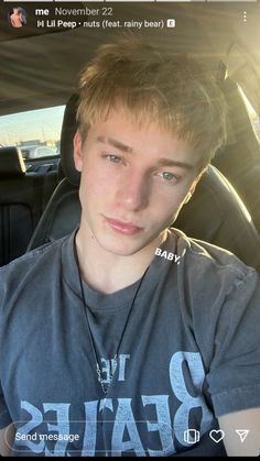 a young man sitting in the back seat of a car looking at the camera with an intense look on his face