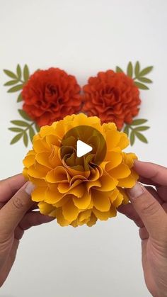 someone is holding up some paper flowers to show off their crafting skills in this video