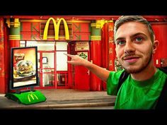 a man pointing at a mcdonald's sign in front of a mcdonalds restaurant