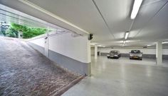 an empty parking garage with two cars parked in the space between it and another car