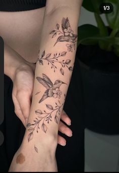 a woman's arm with flowers and birds on it