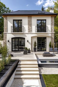 a large white house with lots of windows and steps leading up to the front door