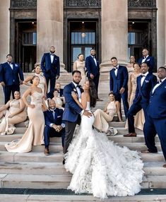 a group of people posing on steps in front of a building with the bride and grooms