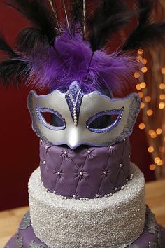 a purple and silver masquerade on top of a cake