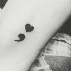 a black and white photo of a person's arm with a heart shaped tattoo on it