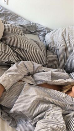 a woman laying in bed with her head under the covers