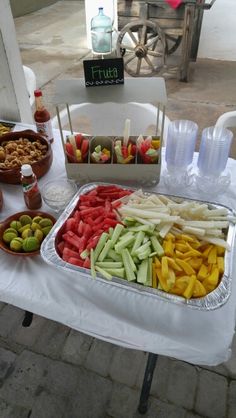 an assortment of fruits and snacks are on a table outside, ready to be eaten