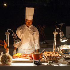 a chef preparing food on a table in front of other foods and utensils