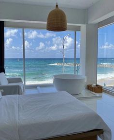 a large white bath tub sitting in the middle of a bedroom next to a window