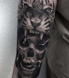 a man with a tiger and skull tattoo on his arm