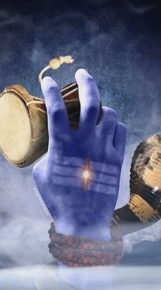 a hand with blue painted hands holding two drums and an object in the air above it