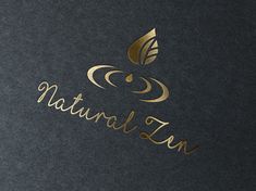 the logo for natural tan is gold and black with a leaf on it's side